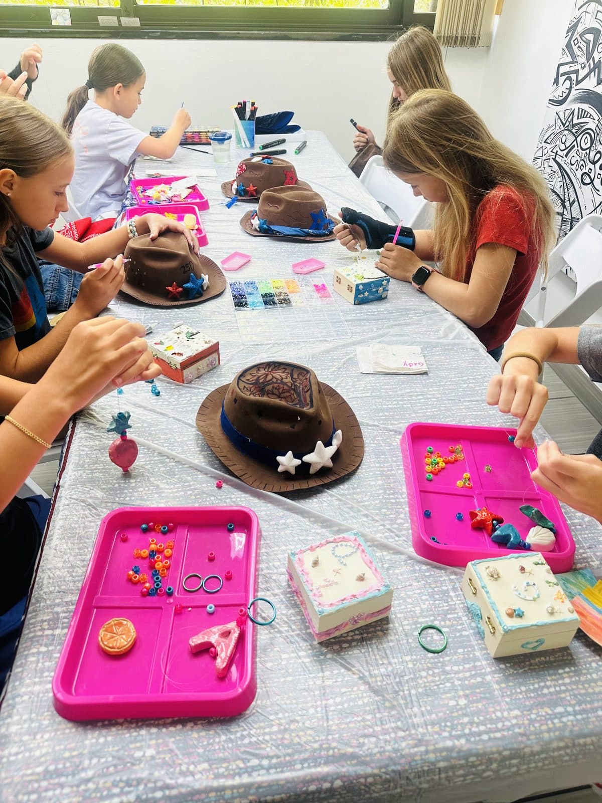 Campers decorating hats and trinket boxes at The Grove Art Studio summer camp